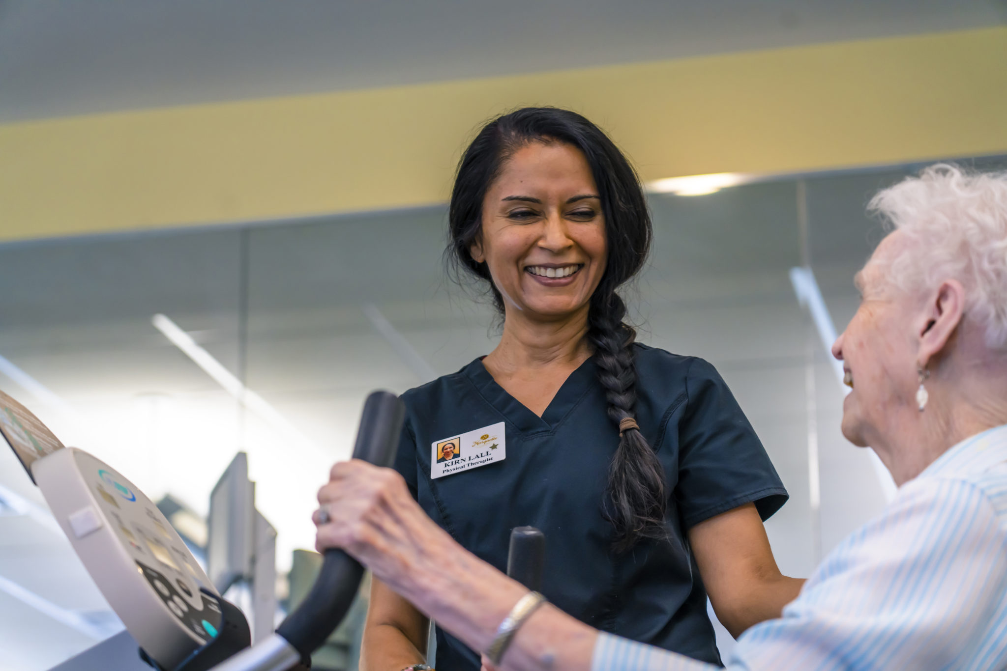 Physical Therapist assists happy senior