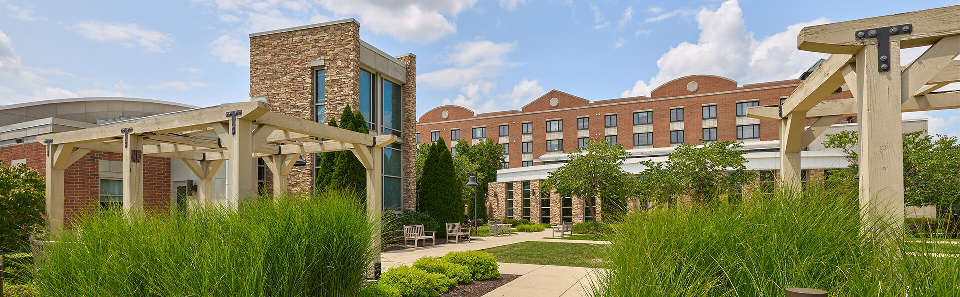 Exterior of Marquette senior living community featuring a pergola, landscaping, and seating area.