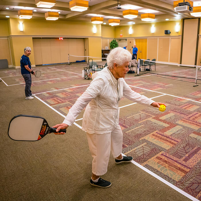 Senior woman serving during Pickleball