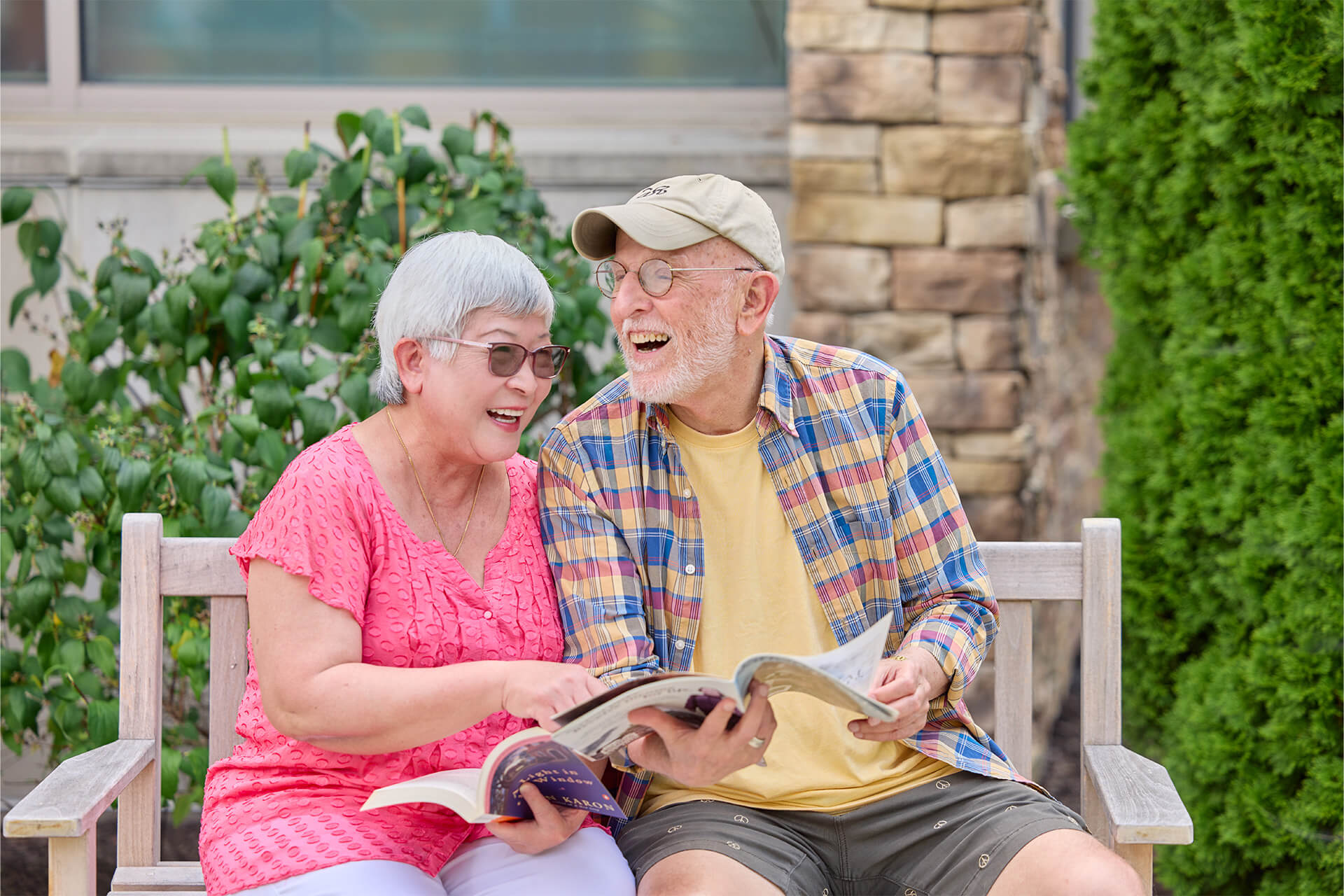 Senior couple sits on bench and laughs together