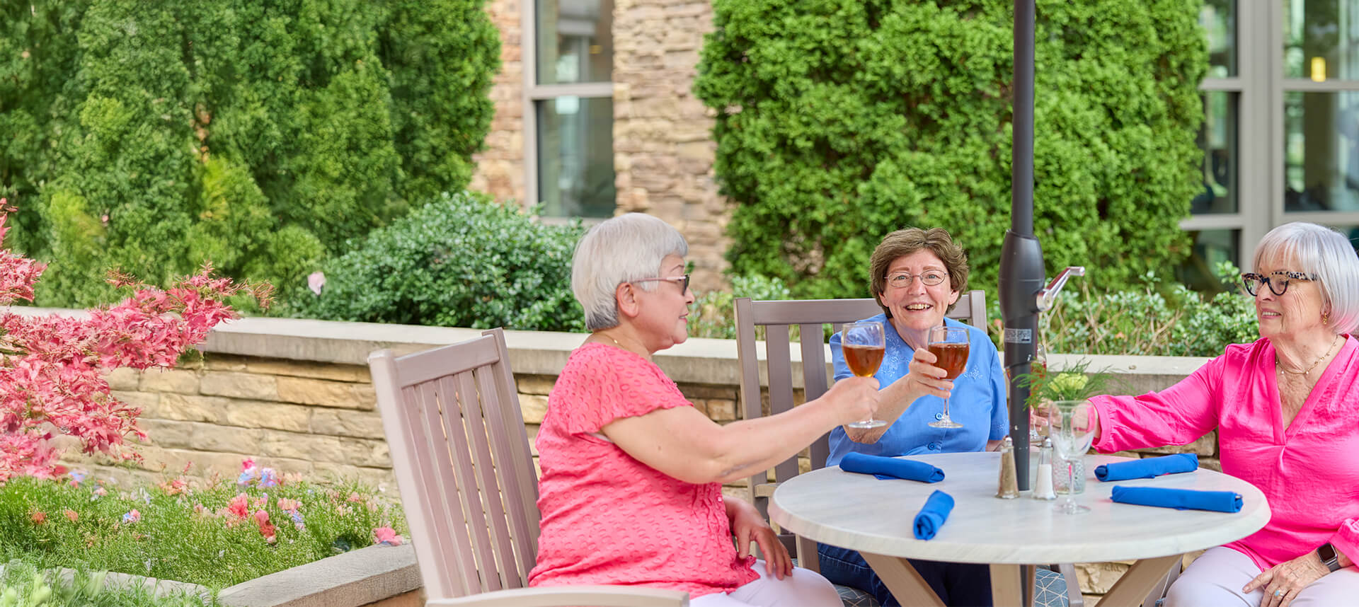 Three senior women drinking wine on the patio